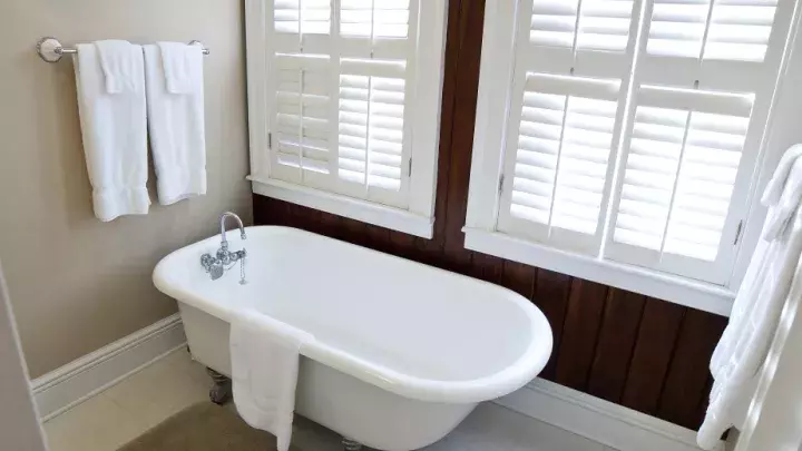 A white clawfoot tub in a bathroom.