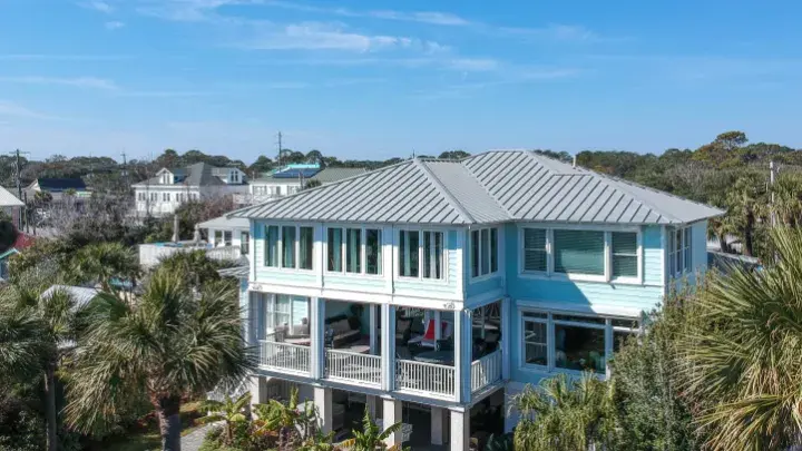 An aerial view of a multi-story home with a backyard pool.