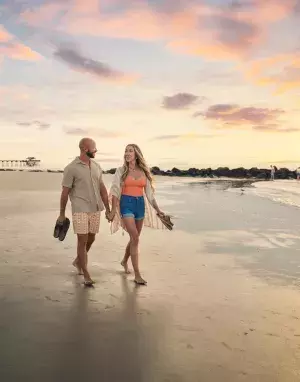 couple walking at sunrise along south beach