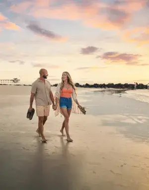 couple walking at sunrise along south beach