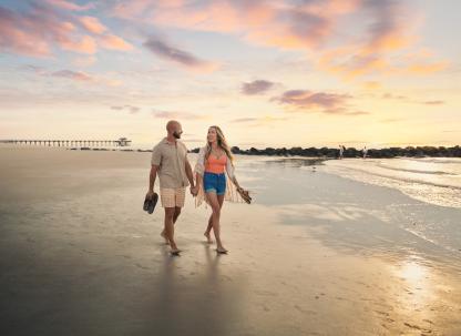 couple walking at sunrise along south beach