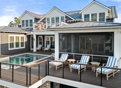 An expansive outdoor back deck with a pool and seating.