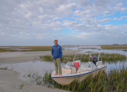 A captain standing on the bow of a boat on Tybee Island, GA.