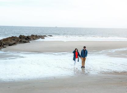 A couple walking the beach on Tybee Island, GA during winter.