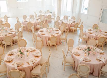Elegant wedding reception setup inside The Chapel by the Sea with blush linens and floral centerpieces.