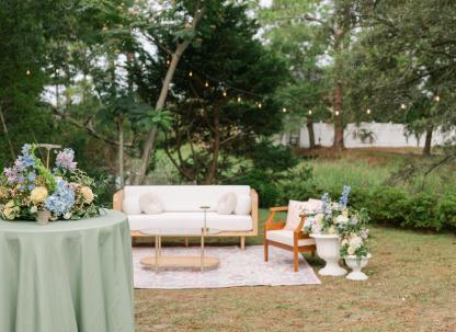 Outdoor wedding lounge with floral arrangements and string lights at The Chapel by the Sea.